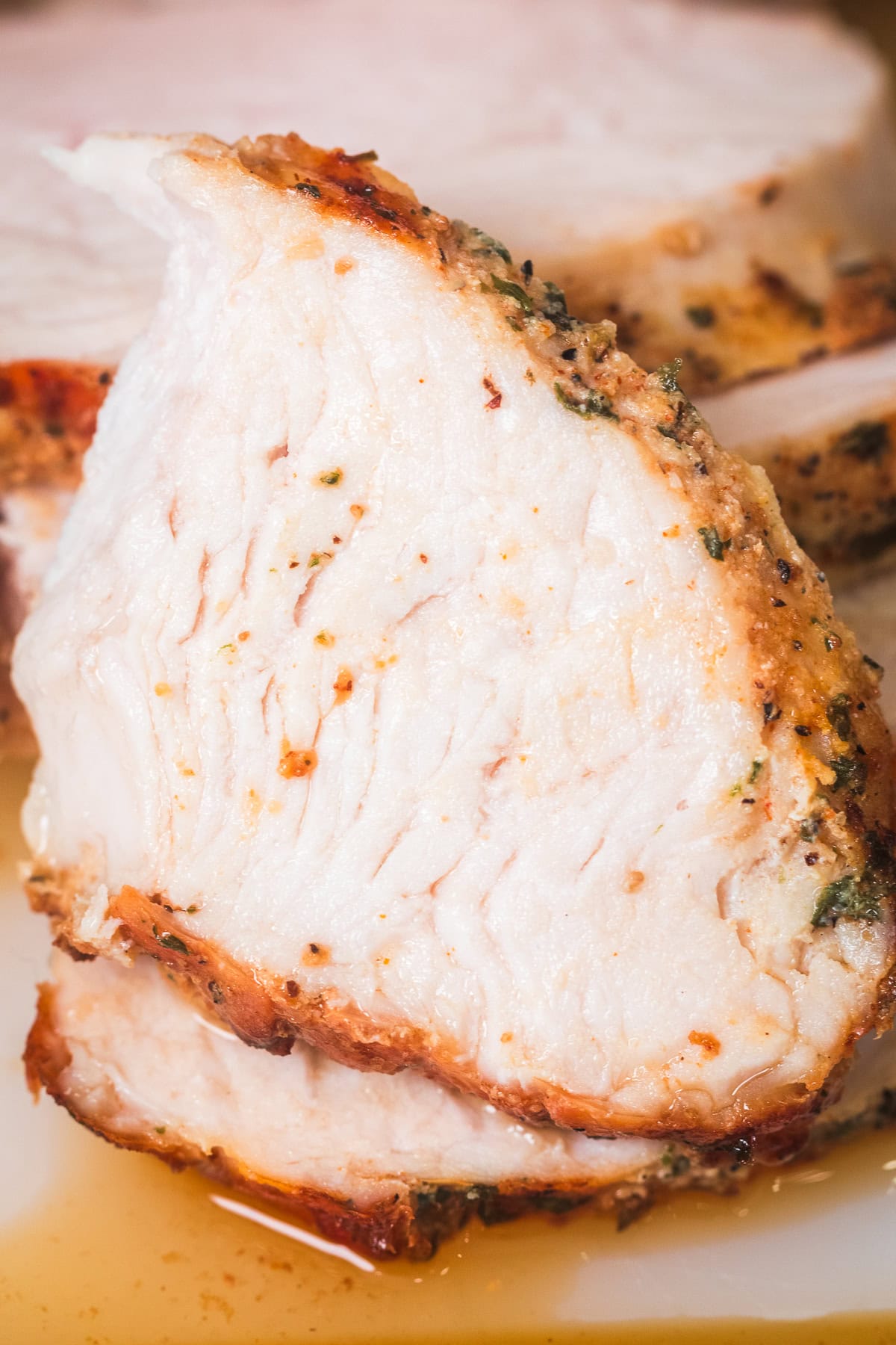 slice of air fryer boneless turkey breast with slices behind it.