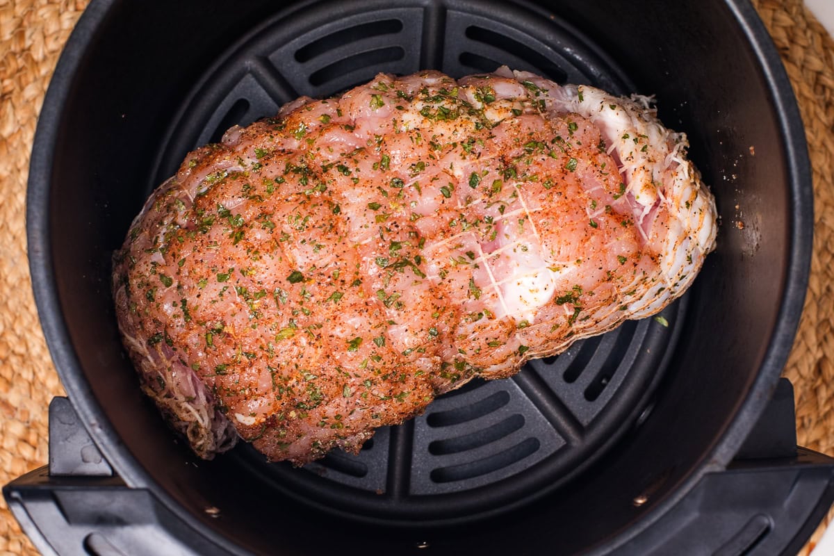 raw butterball boneless turkey breast in air fryer basket.