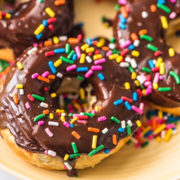 air fryer donuts with chocolate glaze and sprinkles on a yellow plate