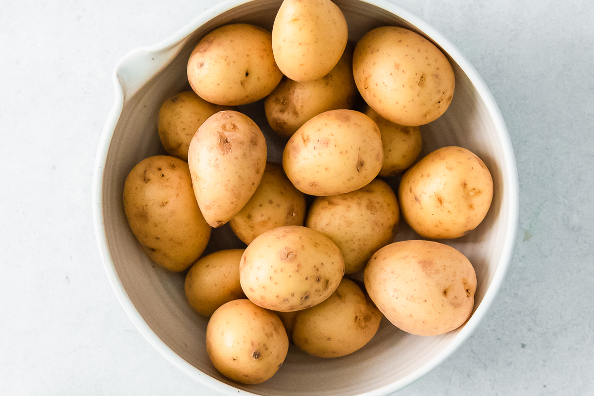 small yellow potatoes in a white bowl.