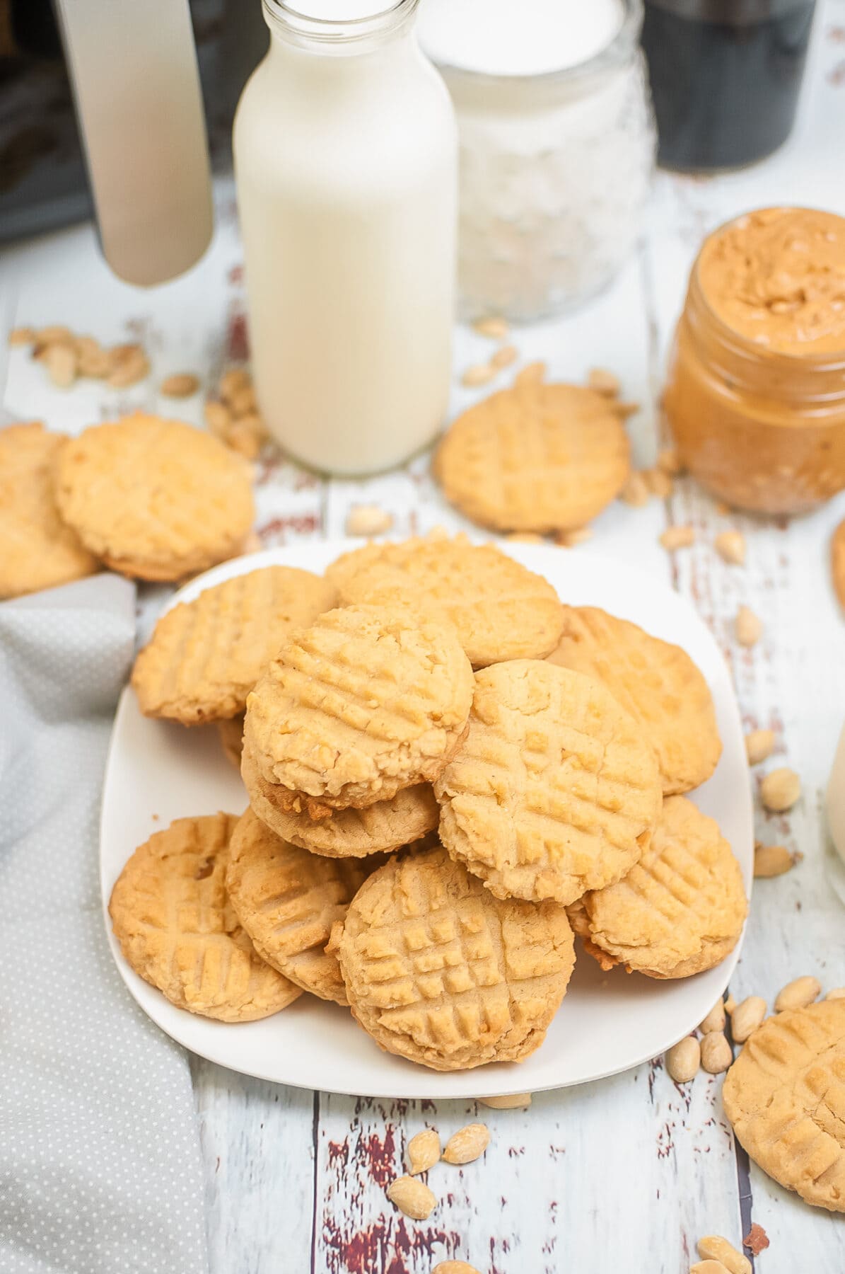 air fryer peanut butter cookies with peanut butter and milk in the background.