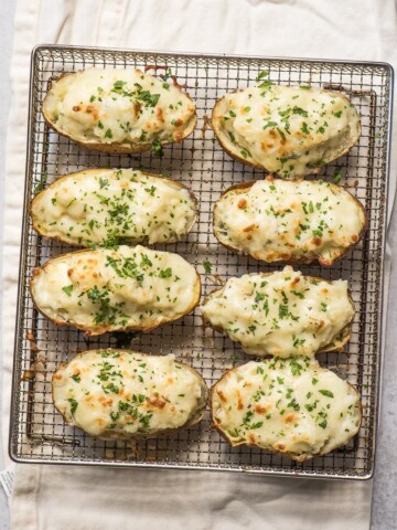 air fryer baked potatoes stuffed with mozzarella cheese on air fryer rack on towel