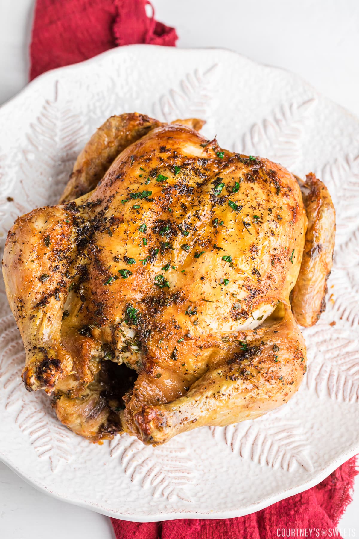 air fryer whole chicken on a white plater.