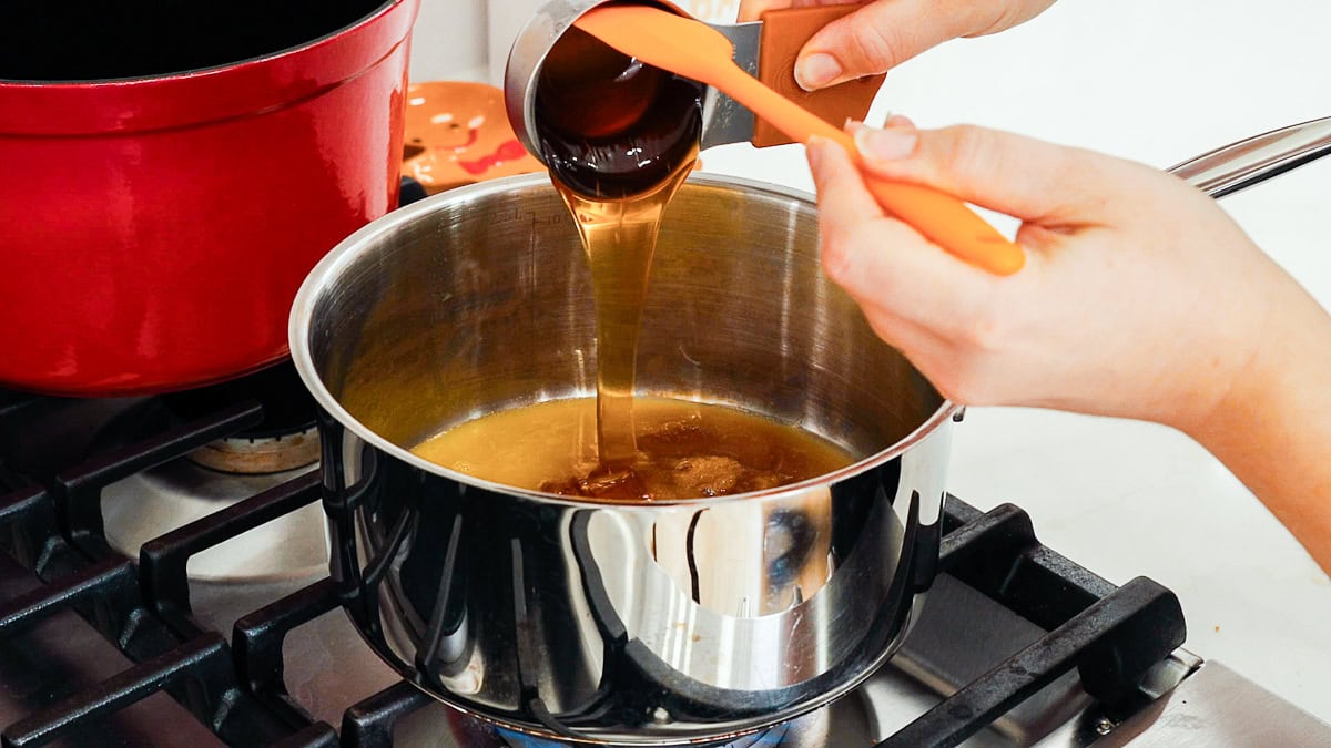 pouring honey into saucepan for ham glaze.