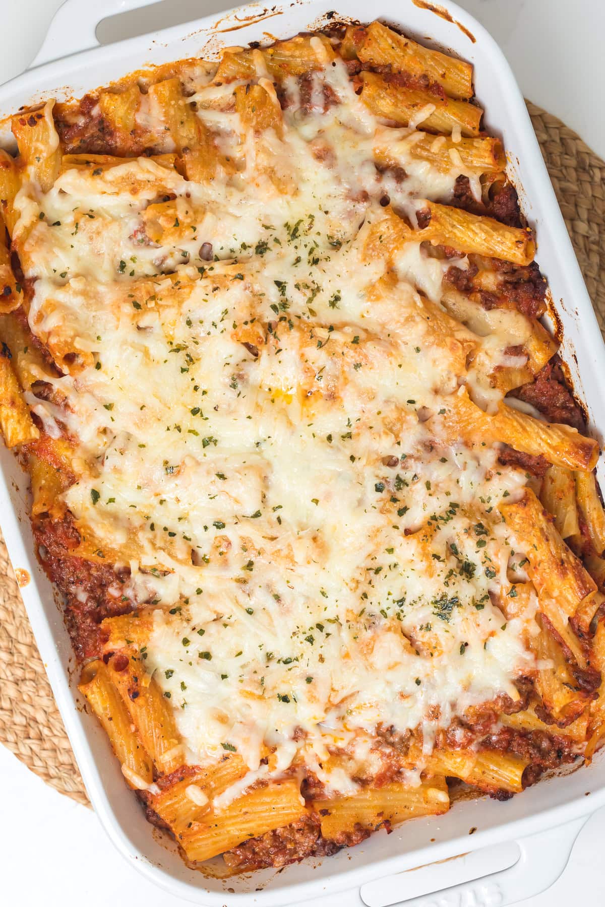 overhead photo of baked ziti without ricotta in a white casserole dish.