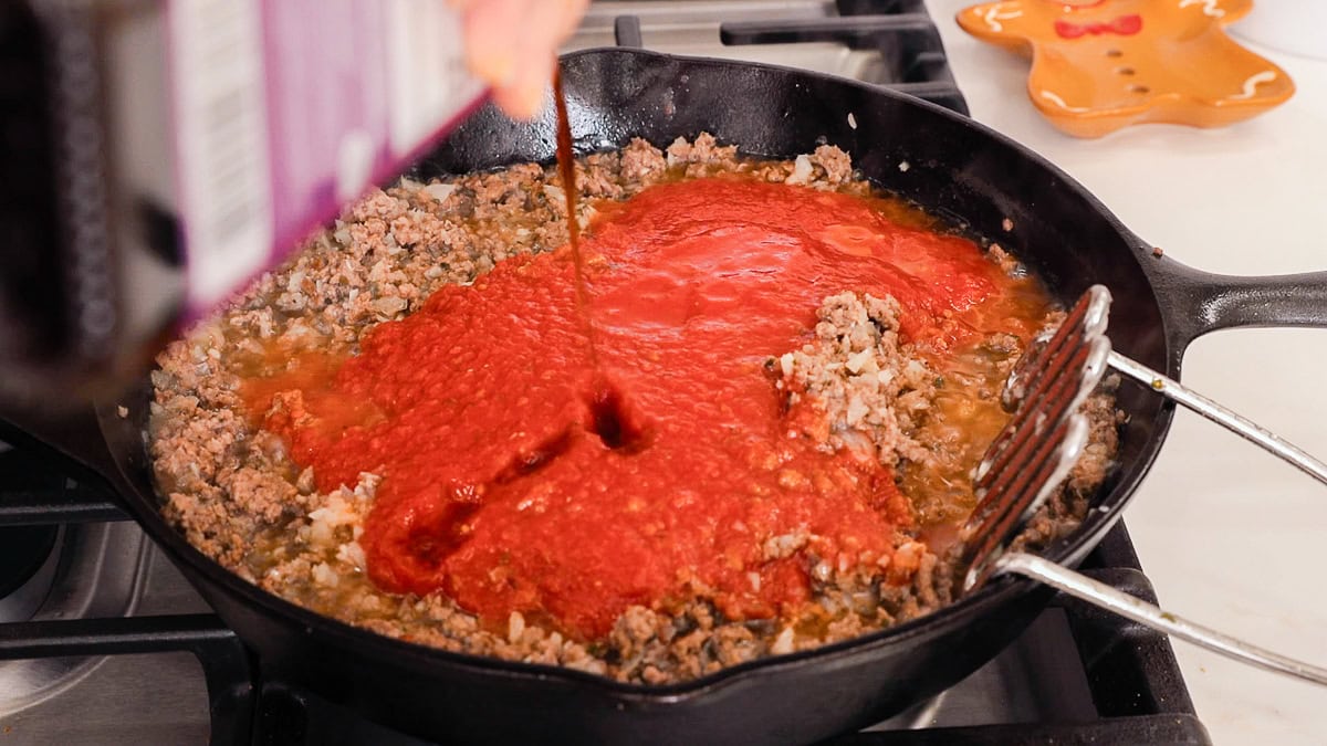 adding balsamic vinegar to meat sauce.