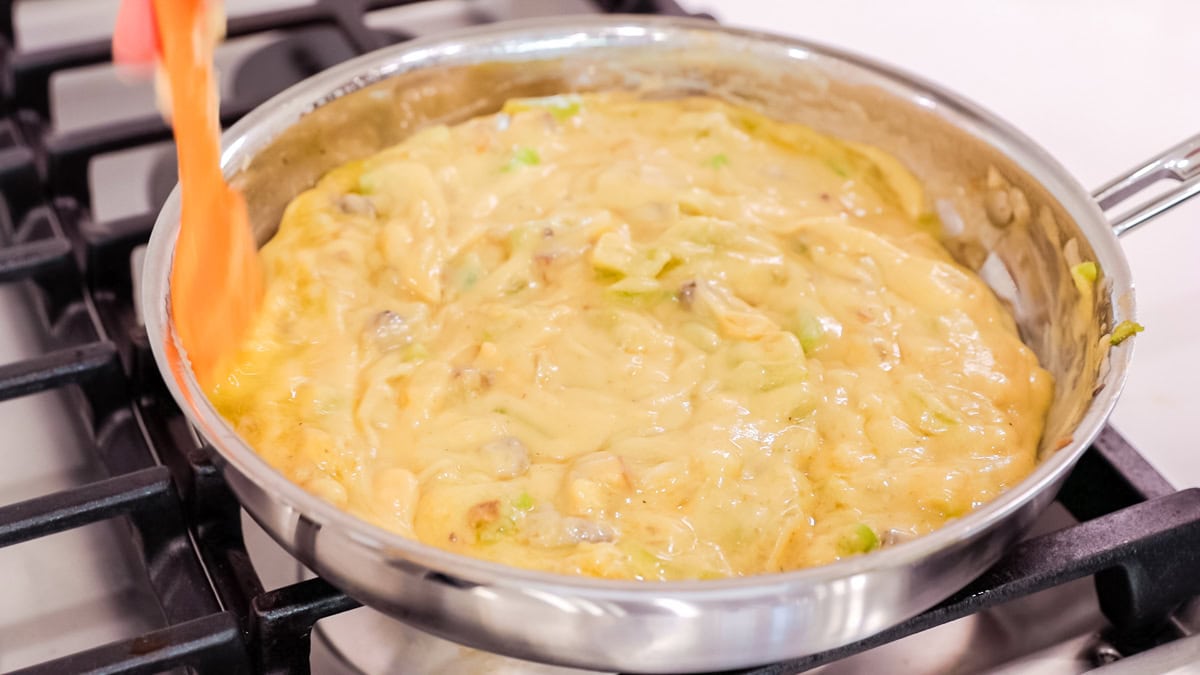 cream of chicken soup mixed in skillet with veggies.