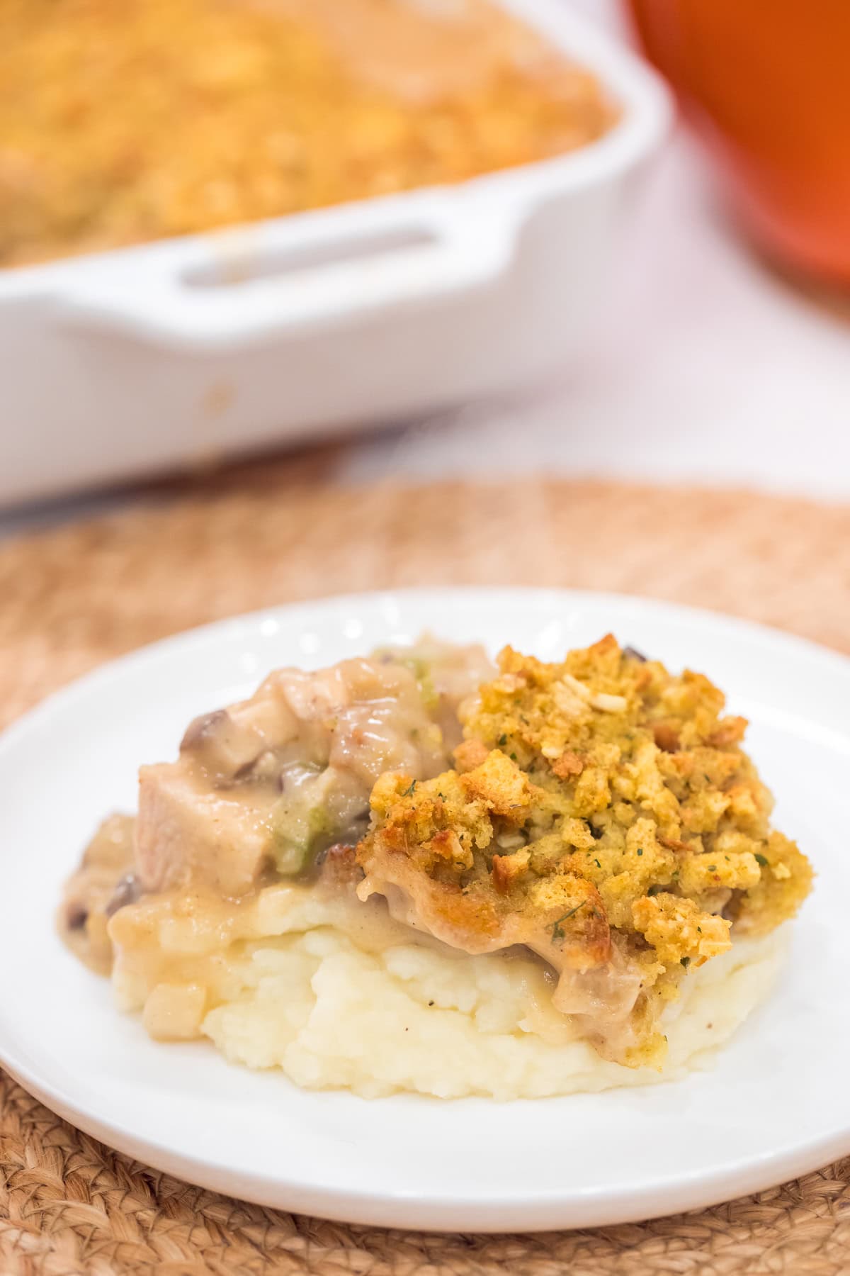 chicken and stuffing casserole served over mashed potatoes on a white plate.