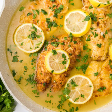 chicken francese in a pan with lemon slices.