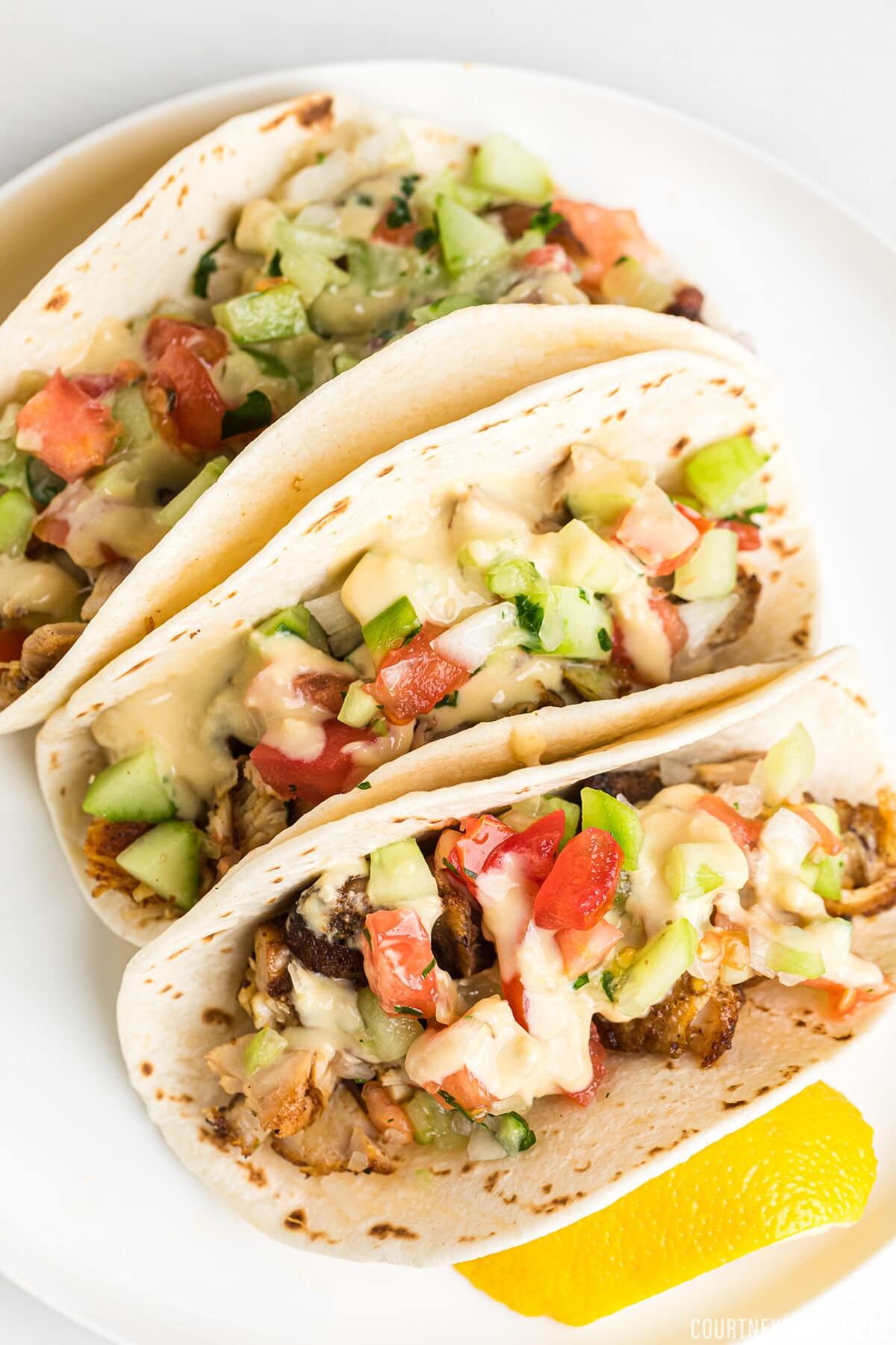 chicken tacos with israeli salad and hummus drizzle