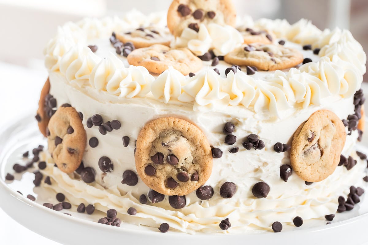 close up of chocolate chip cake with mini chocolate chip cookies on it.