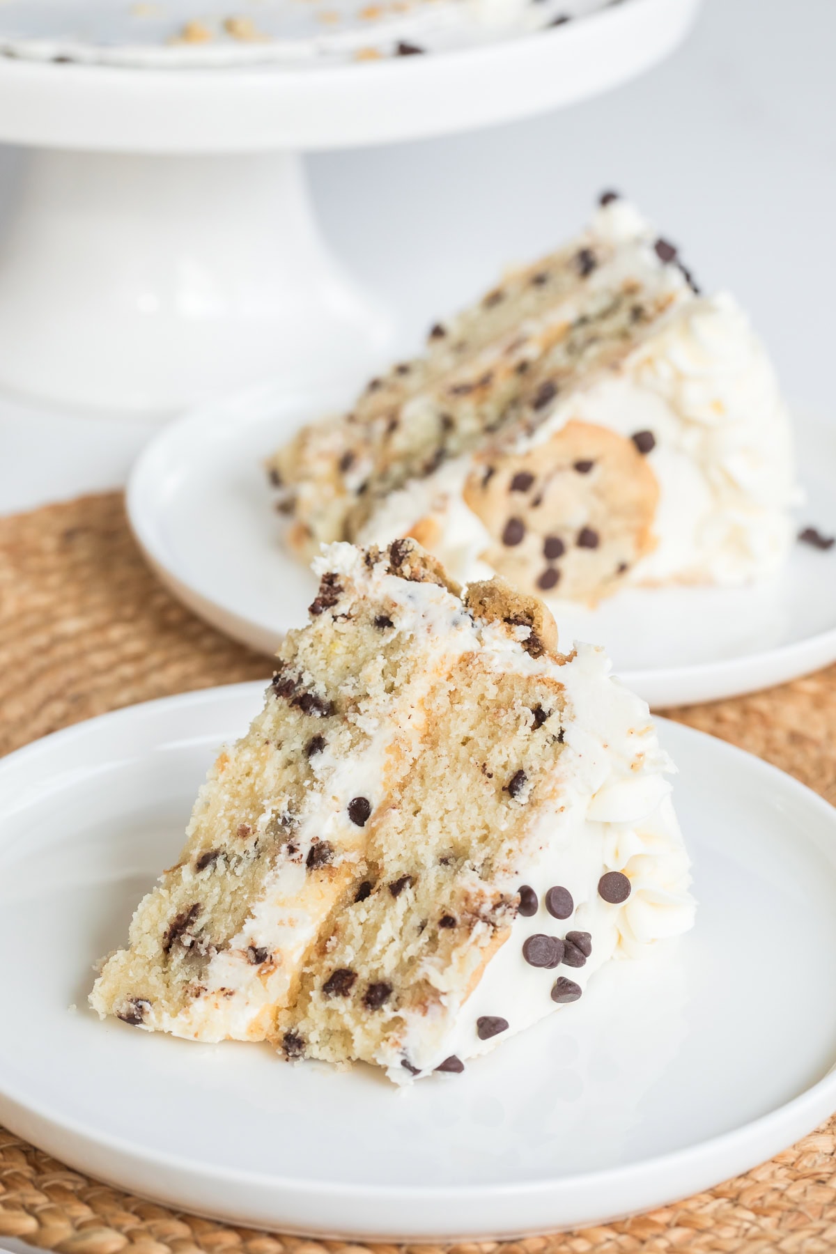 two slices of chocolate chip cake on white plates.