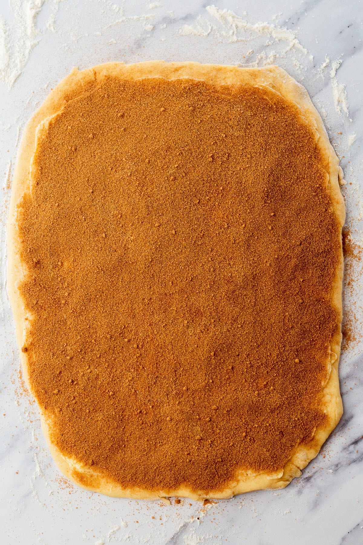 cinnamon sugar on cinnamon roll dough.