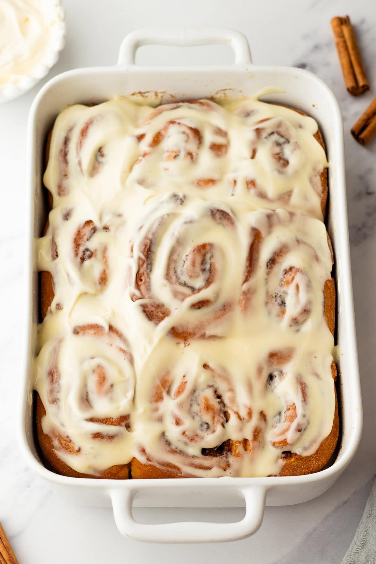 overhead photo of homemade cinnamon rolls in a baking dish.