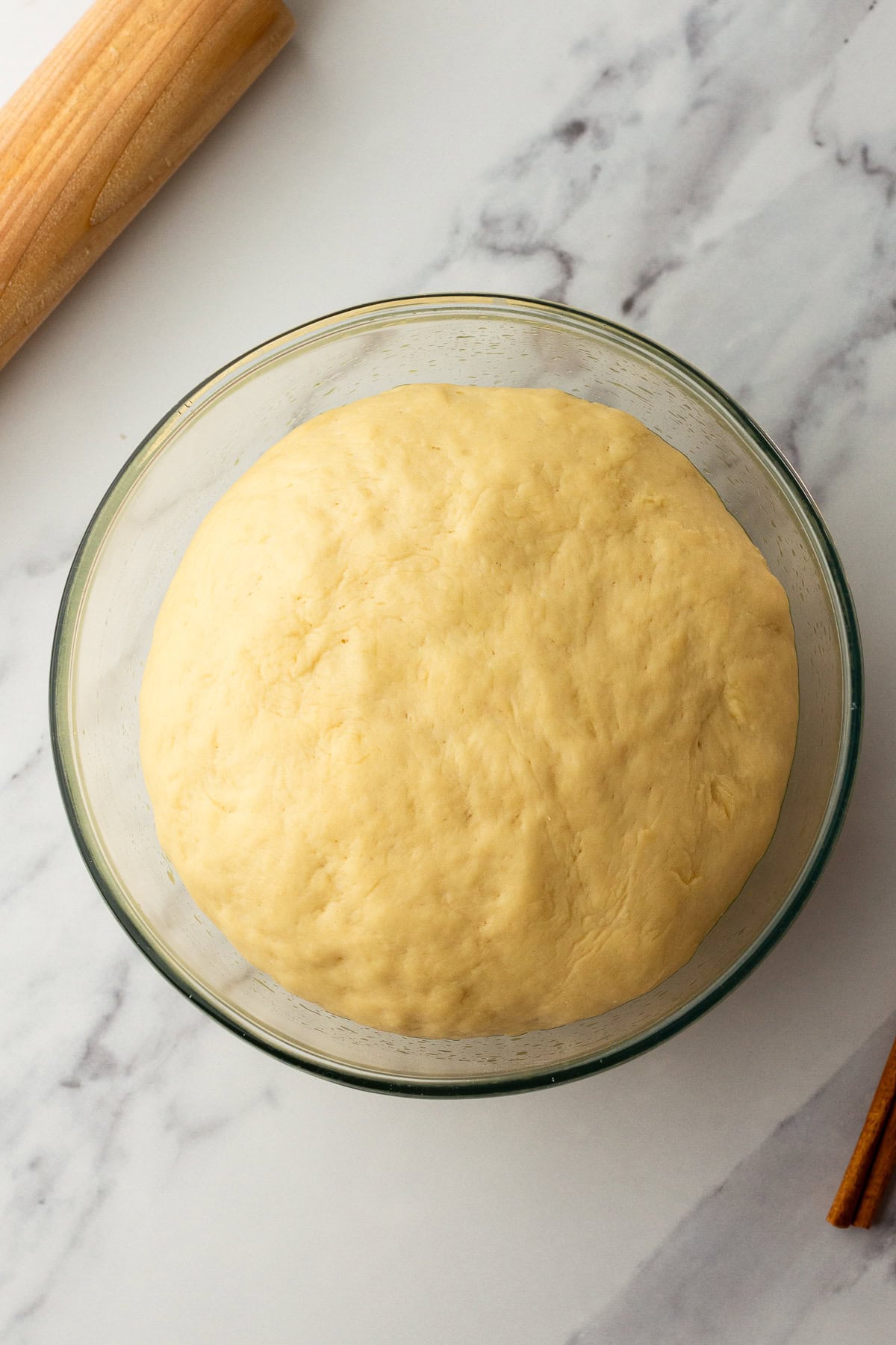 risen cinnamon roll dough in a bowl.