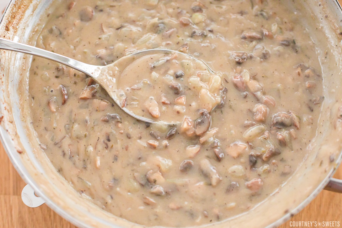 homemade condensed cream of mushroom soup in a skillet with a spoon.