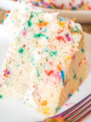 confetti cake slice on a white plate.