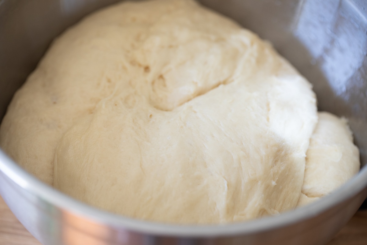 risen donut dough in a bowl.