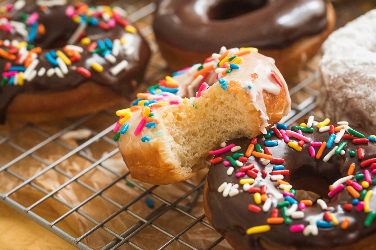 donuts on a cooling rack with one half showing the inside of the donut.