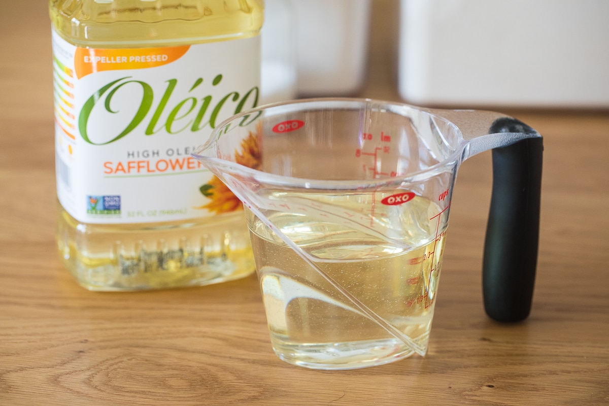 showing how to measure liquid ingredients using a liquid measuring cup with oil in it.