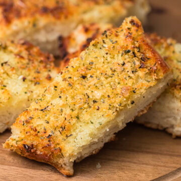 homemade garlic bread sliced on a cutting board.