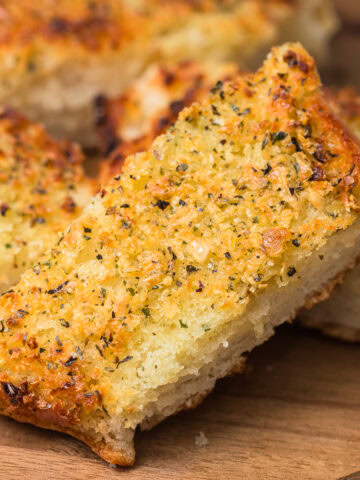 homemade garlic bread sliced on a cutting board.