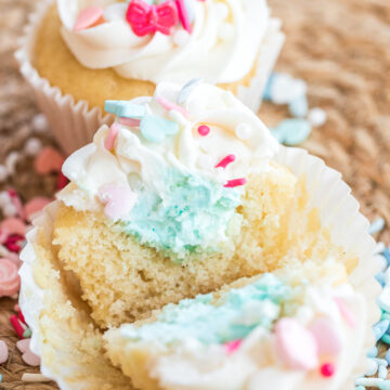 gender reveal cupcakes cut in half showing blue frosting for boy.