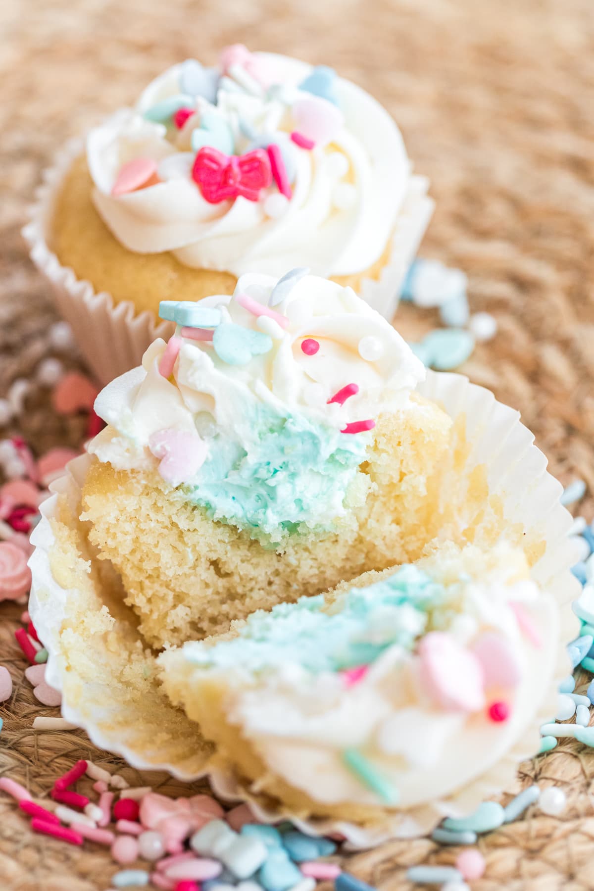 gender reveal cupcakes cut in half showing blue frosting for boy.