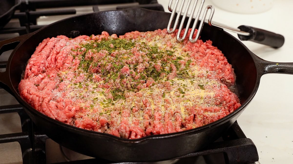 seasoned raw ground beef in cast iron skillet.