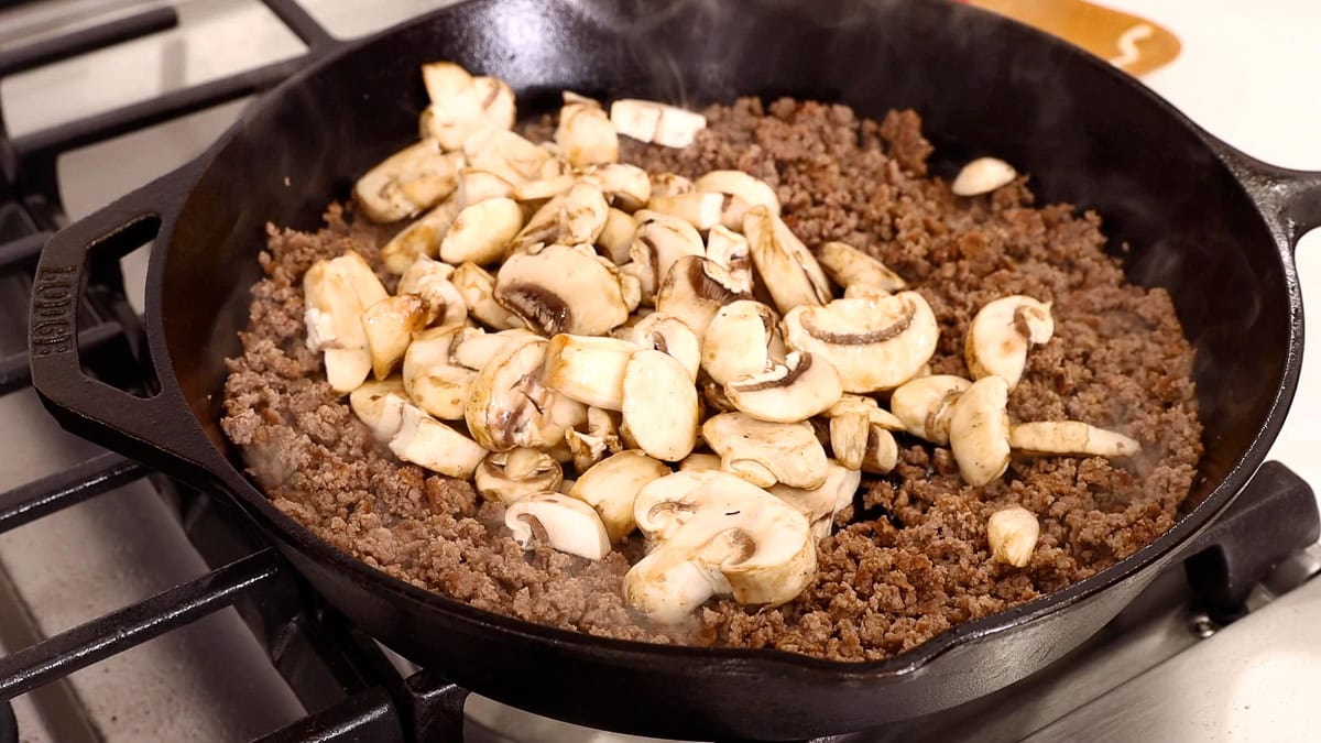 mushrooms added to ground beef in skillet.