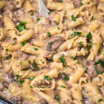 ground beef stroganoff in a cast iron skillet with a serving spoon.