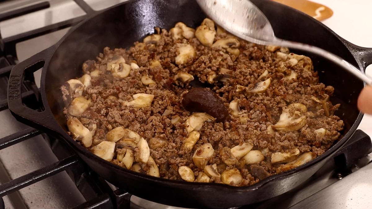 bouillon added to ground beef mixture in skillet.