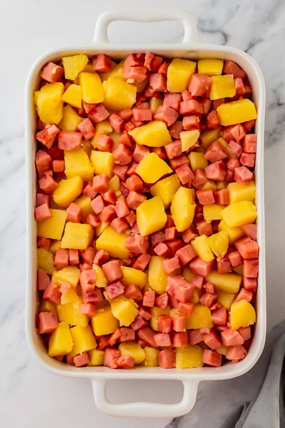 potatoes and ham in a casserole dish.