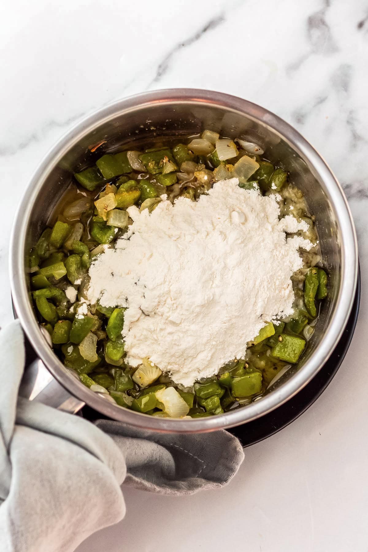 flour added to seasoned veggies in a saucepan.