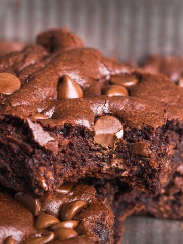 homemade brownie recipe in a baking dish with a bite taken out of one.