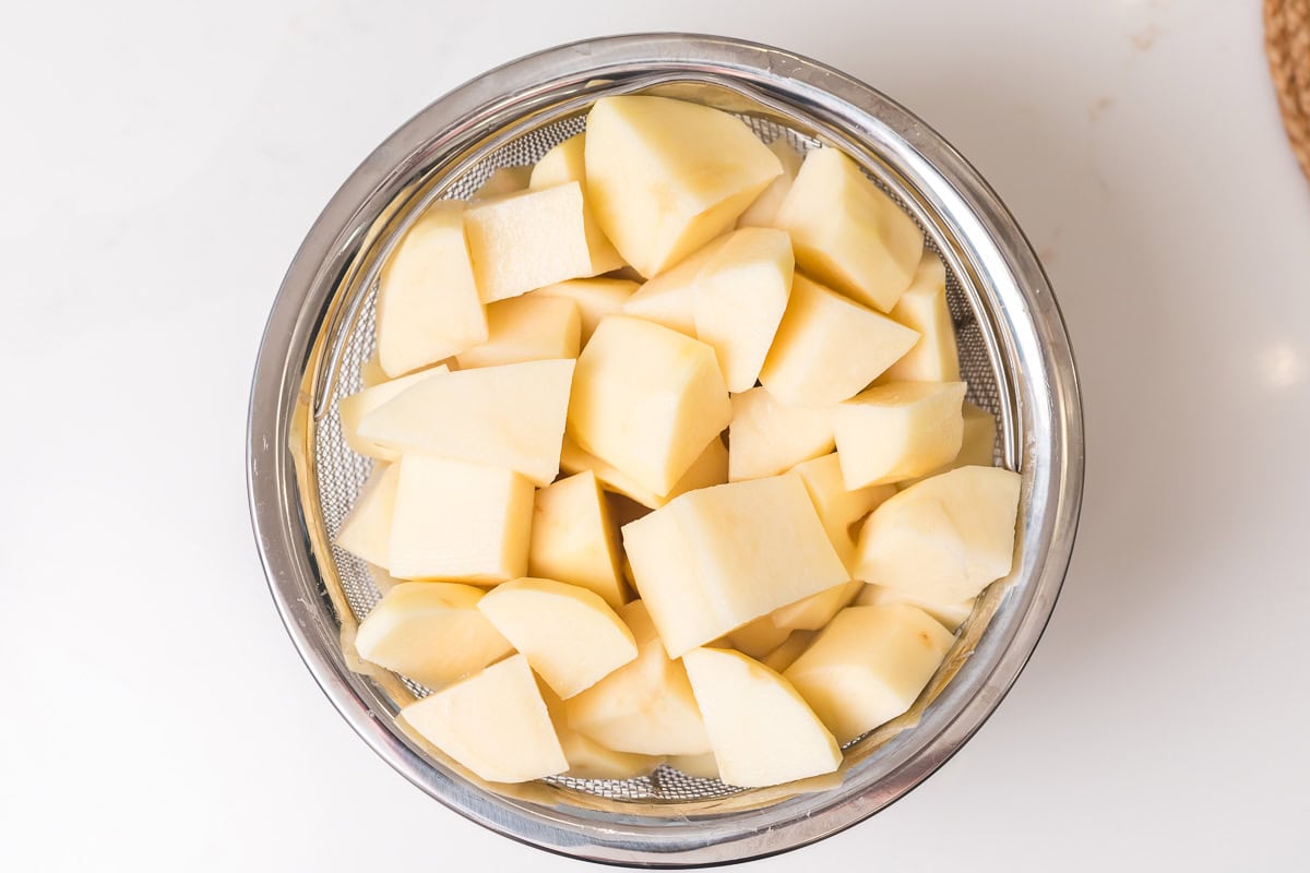 overhead photo of raw potatoes in a steamer basket insert for the instant pot.