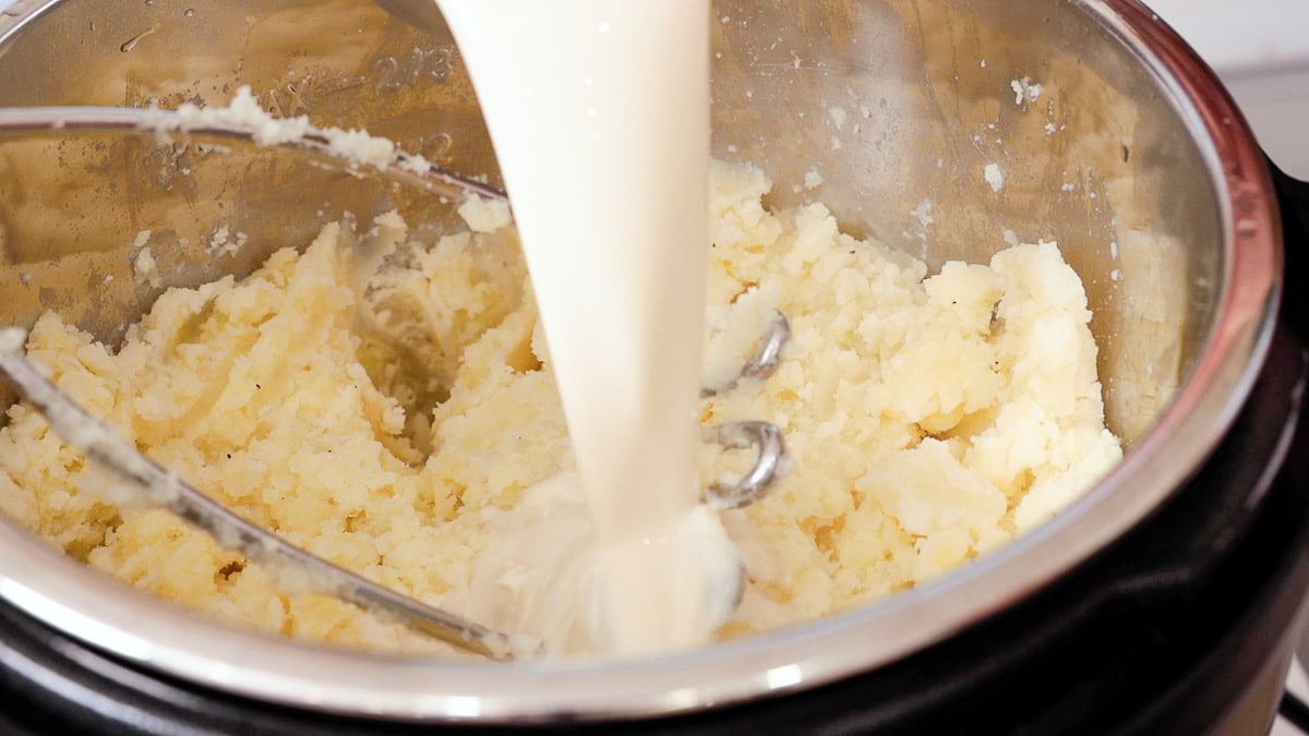 milk pouring into mashed potatoes in the instant pot.