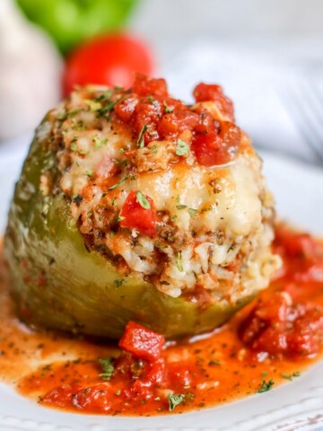 instant pot stuffed pepper on a plate covered in chunky tomato sauce