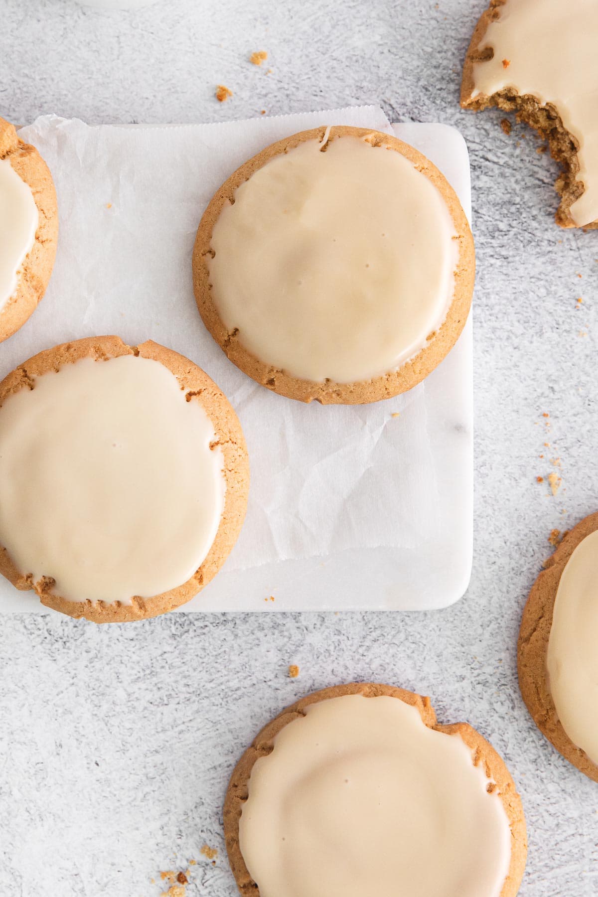 maple cookies scattered on parchment and counter.