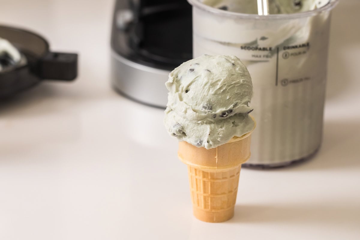 dairy free mint chocolate chip ice cream made in the ninja creami in a ice cream cone.