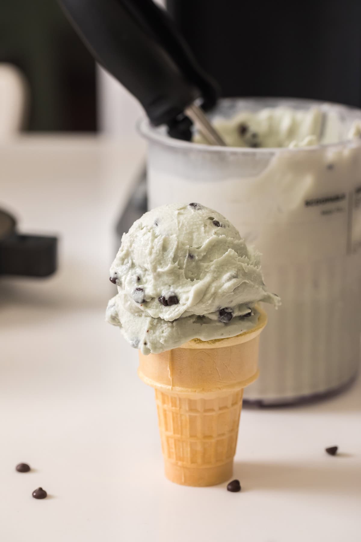 homemade mint chocolate chip ice cream in a ice cream cone made in the ninja creami deluxe.