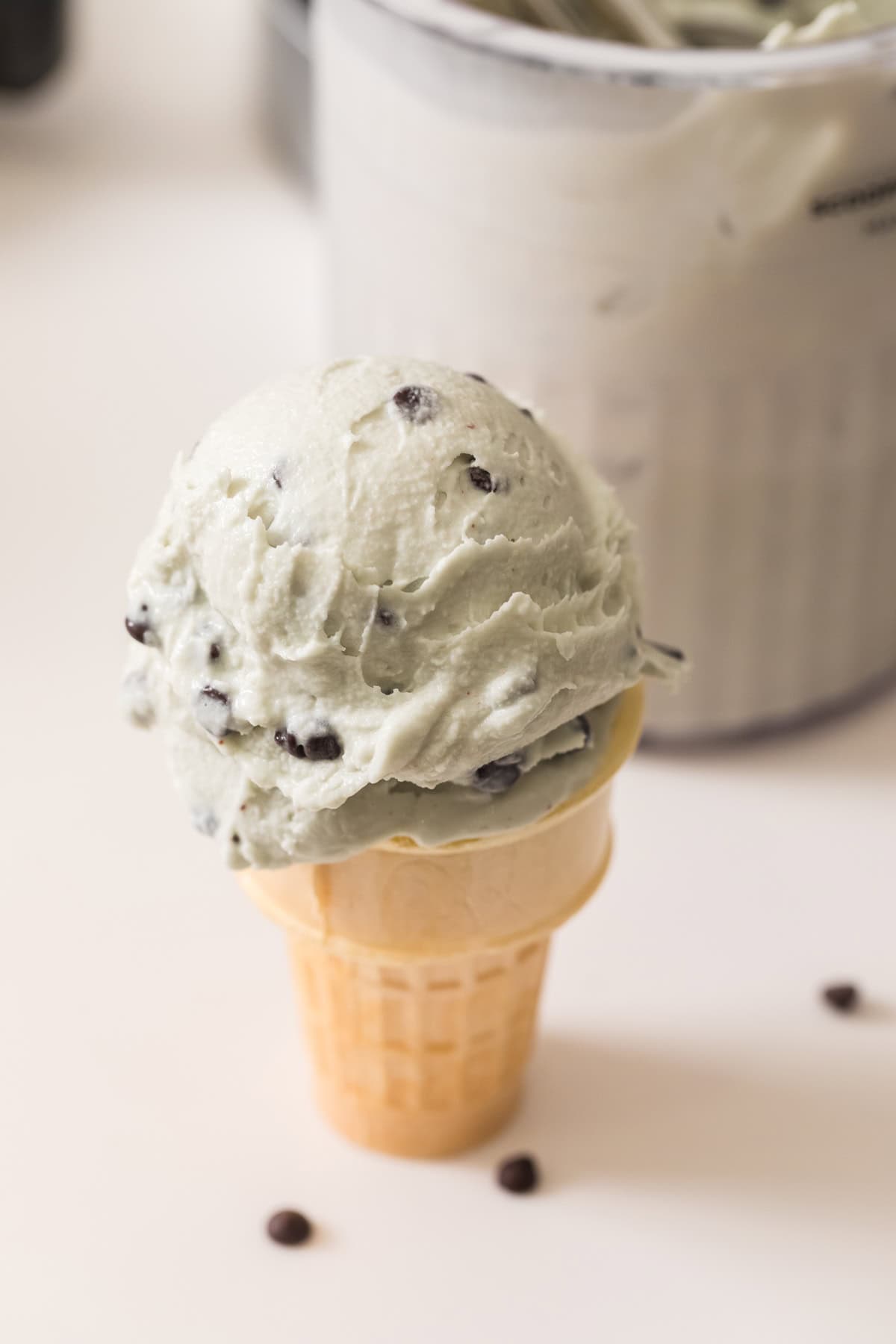 mint chocolate chip ice cream in a cone.
