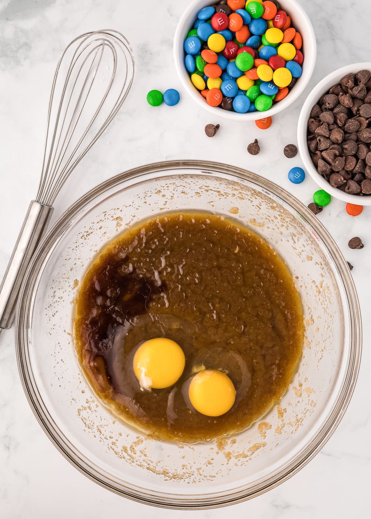 sugar and butter mixture in a glass bowl with eggs and vanilla added.