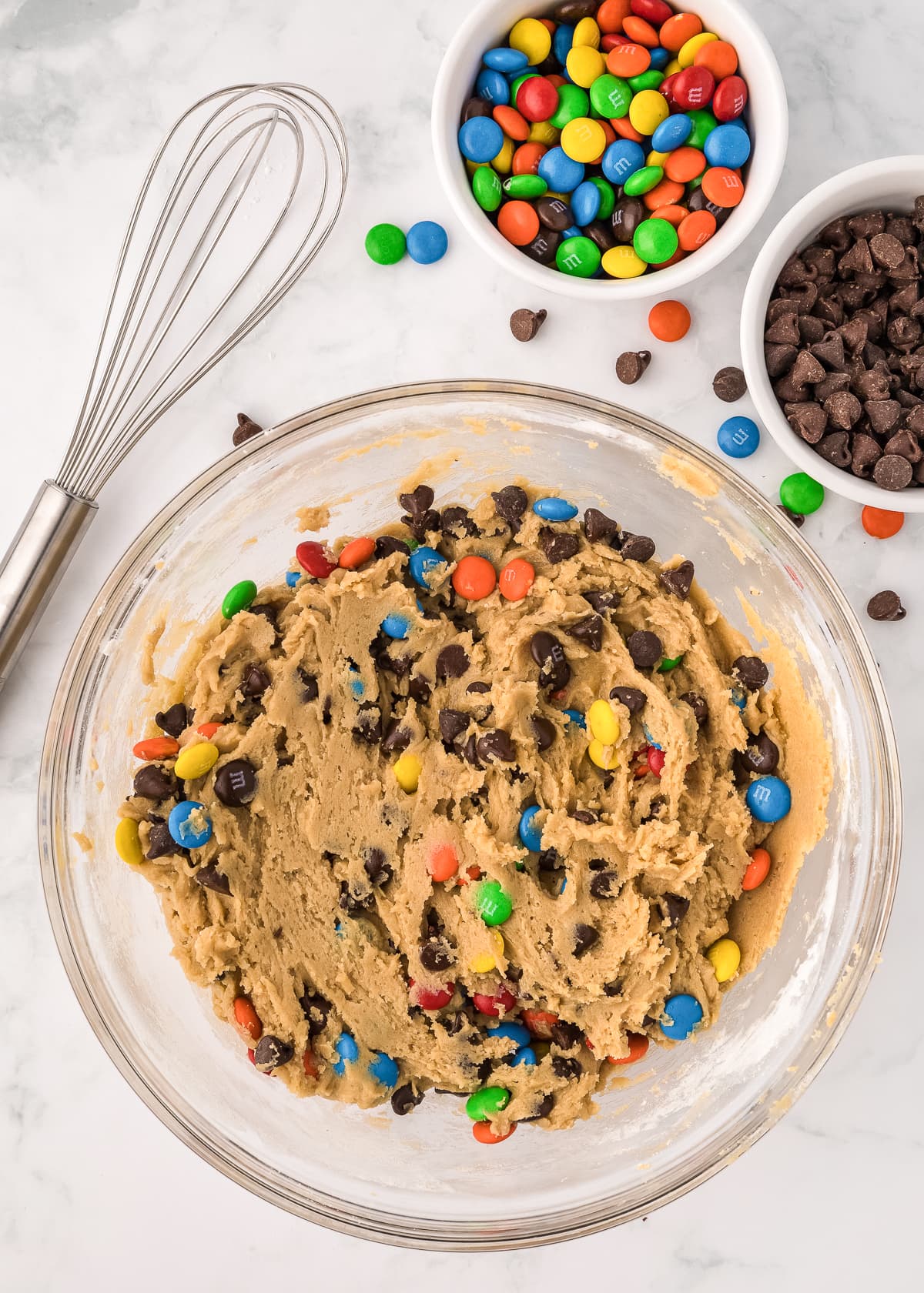 m&m cookie bars batter in a glass bowl.