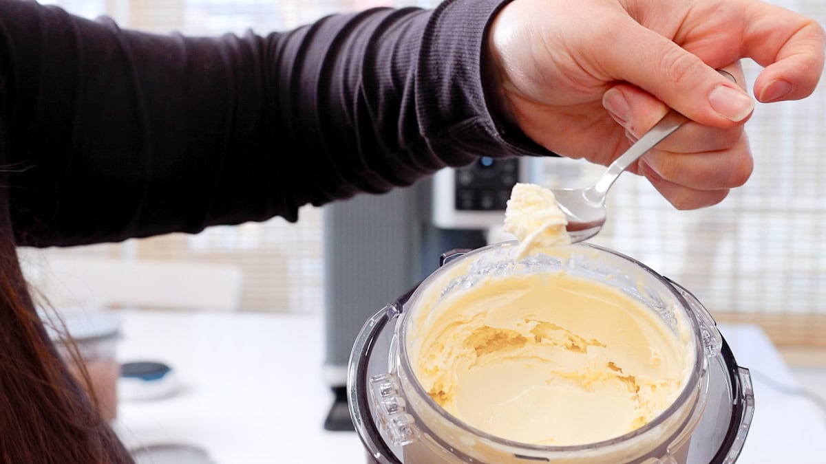 showing the creamy texture of the ninja swirl soft serve with the container in view and on a spoon.