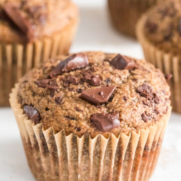 close up of oat flour banana muffin with muffins behind it.