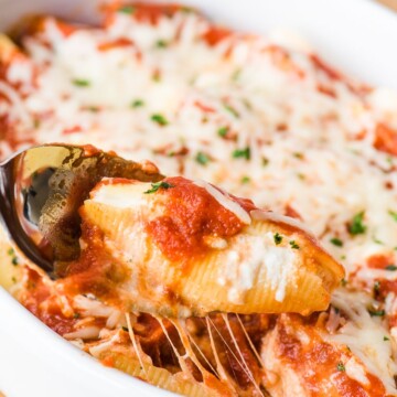 ricotta stuffed shell on a spoon in a casserole dish