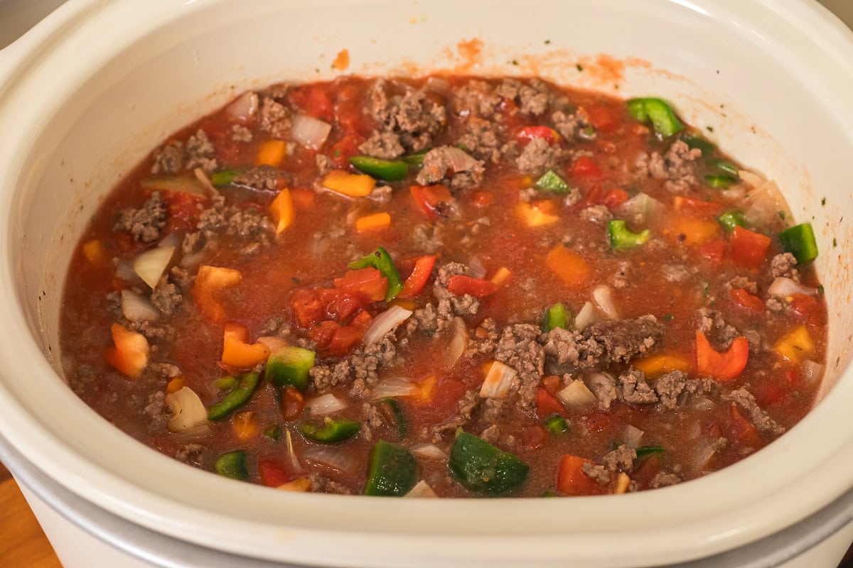 mixed ingredients in slow cooker for stuffed pepper soup.