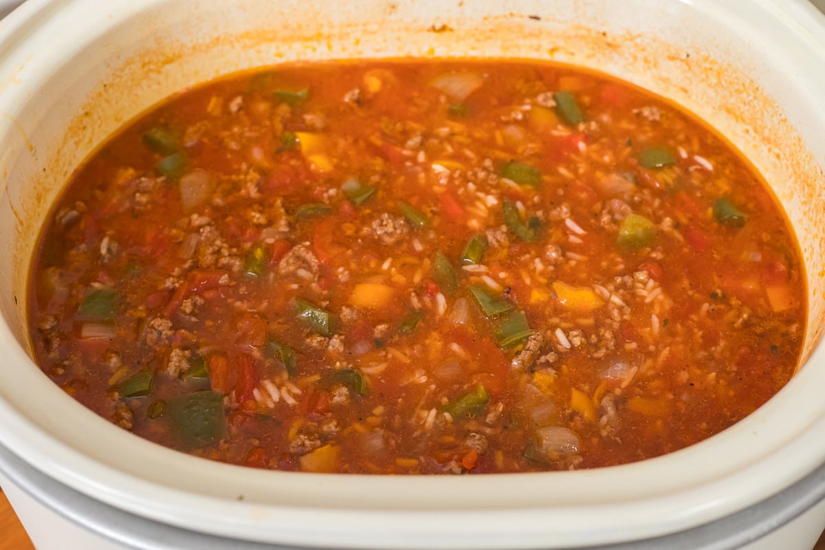 ingredients in slow cooker for stuffed pepper soup cooked and rice added.