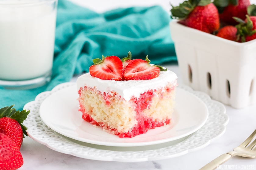 strawberry poke cake on a white plate.